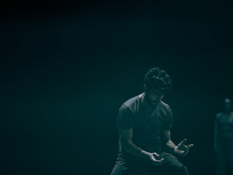 Person performing a fluid movement in a spacious, minimalist studio.